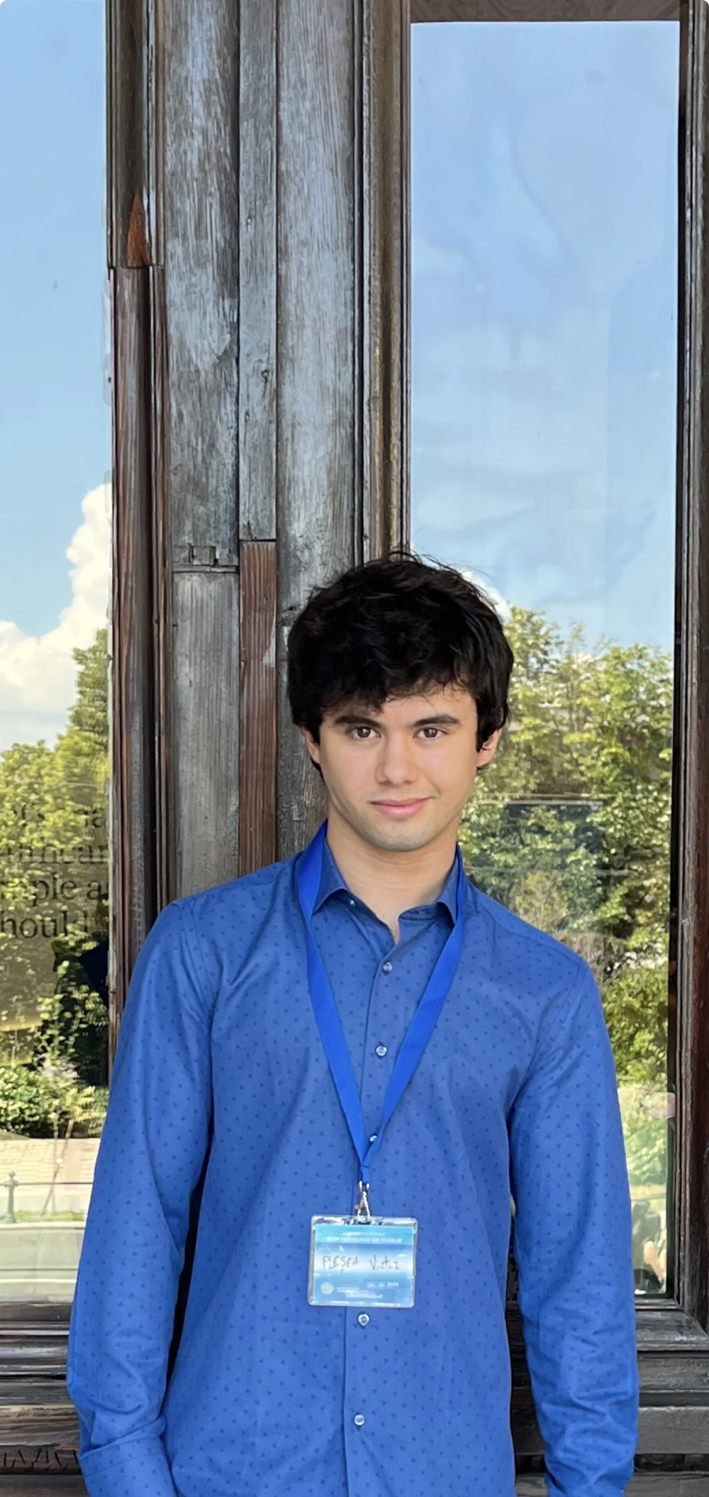 Victor photographed in a blue shirt outside a building.